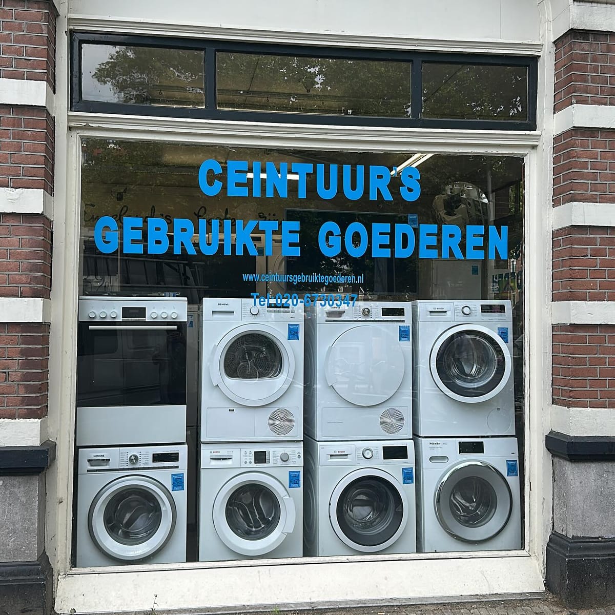 De etalage van Ceintuur’s Gebruikte Goederen met wasmachines, drogers en een fornuis